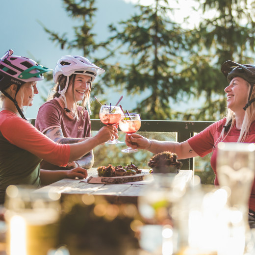 Kulinarik nach dem Biken in Saalbach | © Mia Knoll Three women having a snack at the mountain hut in Saalbach Hinterglemm | © Mia Knoll