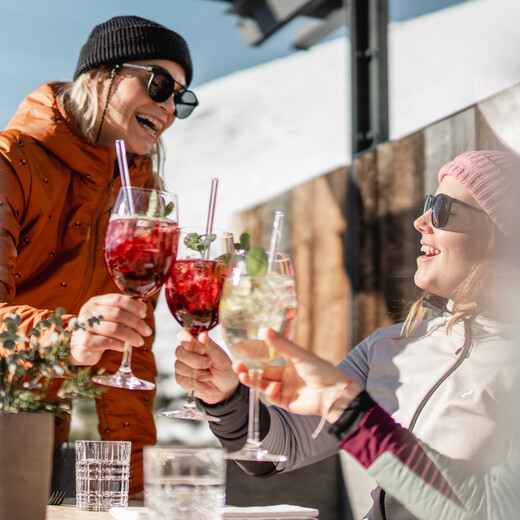 Skifahrer stoßen mit Getränken auf einer Skihütte in Saalbach Hinterglemm an | © Christoph Johann