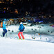 Nachtskifahren in Saalbach Skifahrer bei Nacht auf der Skipiste mit Blick ins Tal