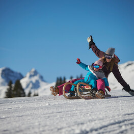 Mutter mit Kind beim Rodeln in Saalbach Hinterglemm | © saalbach.com, Daniel Roos