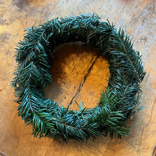 Den Strohkranz mit Tannenzweigen umwickeln