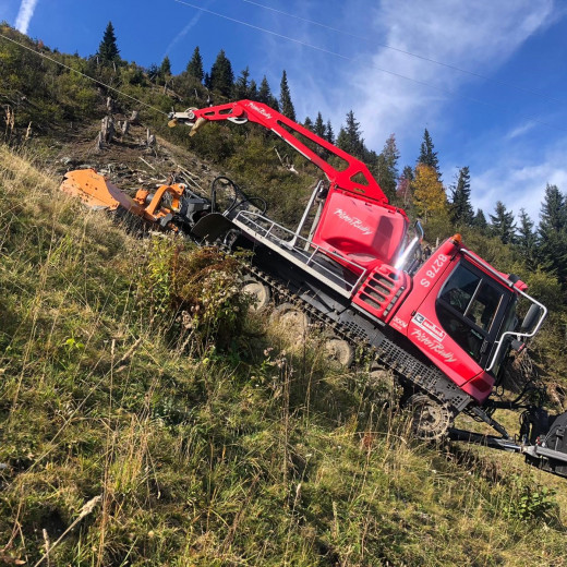 A piste groomer in summer-action